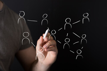 A hand draws interconnected people on a virtual screen, symbolizing digital networking, social connections, global communication, and business c