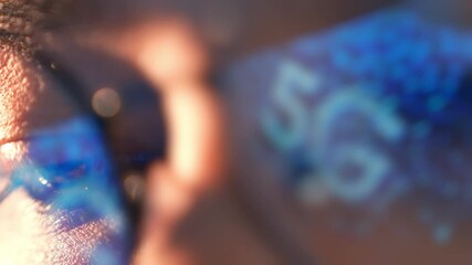 A close-up of a person’s eye with the 5G reflected in their glasses represents digital transformation, real-time connectivity, innovation in smart devices, and the changing way we access information.
 - Powered by Adobe