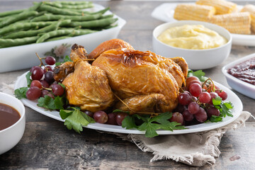 Thanksgiving dinner on rustic wooden table with turkey,mashed potatoes,ears of corn and green bean casserole