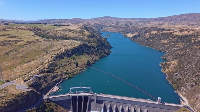 Backward drone flight reveals Roxburgh Dam on the Clutha River, a key hydroelectric station in Central Otago, New Zealand.