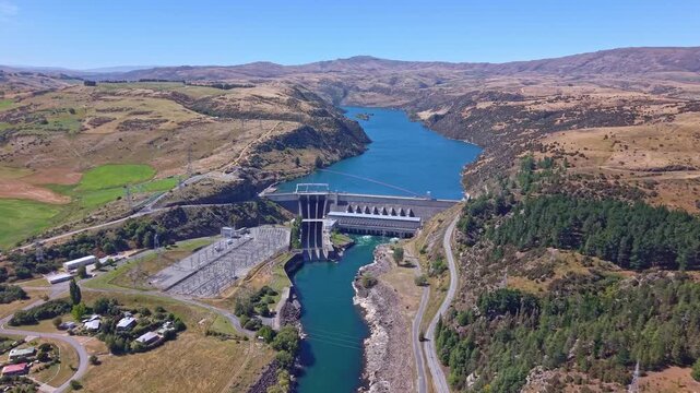 Drone flight approaching the massive Roxburgh Dam on New Zealand&rsquo;s Clutha River, showcasing its hydroelectric infrastructure and surrounding landscape up close.