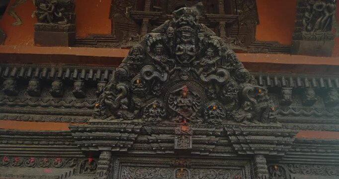 Pashupatinath Temple, Kathmandu, Nepal. Intricate wooden carvings depict gate guards, gods, snakes, and protective mantras with tika and chandan, showcasing Hindu artistry, heritage, and spirituality