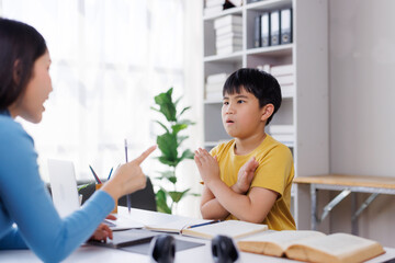 Obraz premium Asian teacher scolding elementary student at school desk