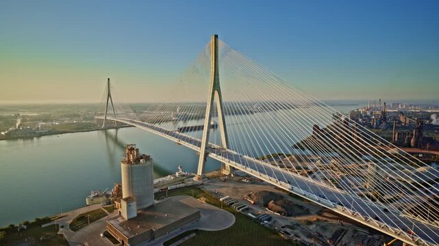 Drone capture of a Great Lakes freighter gliding below the span of the Gordie Howe International Bridge.