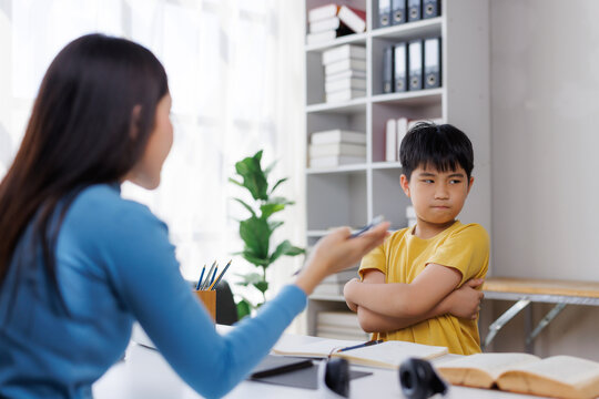 Stubborn asian boy arguing with tutor during private lesson