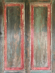 Close up of colorful vibrant rustic wood door panel with carving and red frame. In rustic brown wood, and corroded rusty colors and red paint. Old vintage, traditional, and retro feel. Seamless
