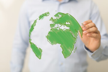 Businessman's hand creating a digital green globe. This image represents environmental awareness,...