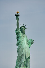 Obraz premium Wide-angle shot of the Statue of Liberty as seen from ferry cruising through New York Harbor