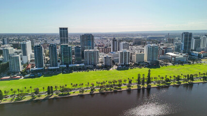 Drone shot of Perth cityscape from Swan River showing skyscrapers under bright sunlight