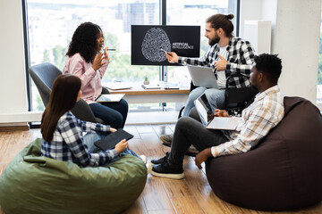 Young professionals brainstorming on artificial intelligence project. Workplace includes diverse team, casual setting, modern technology, relaxed collaborative atmosphere