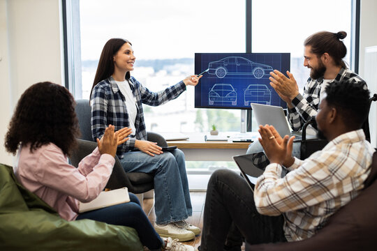 Diverse team of young adult engineers and designers having car blueprint presentation. Focus on teamwork, innovation, and collaborative design. Positive interaction includes clapping