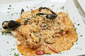 Close-up of delicious fish pasta cooked with fresh tomatoes and garlic sauce on a dish