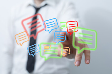 A hand touches glowing speech bubbles, symbolizing digital communication, social networking, and the importance of modern technology.