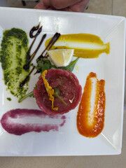 Delicious meat platter with assorted vegetable sauces artistically presented on a white plate