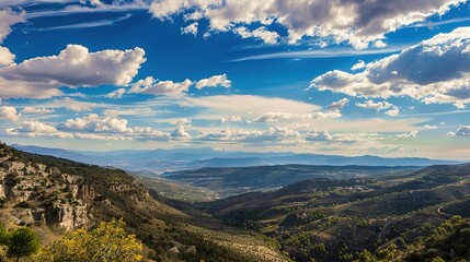 Scenic Mountain Valley Under Blue Sky. It shows a beautiful mountain valley with a clear blue sky and clouds. Great for nature photography collections, travel brochures, or outdoor adventure promotion