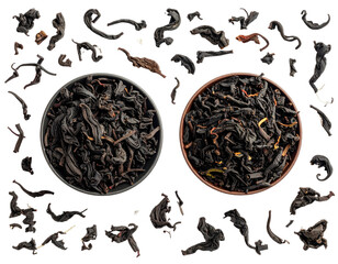 Two dark tea bowls filled with loose leaf tea, surrounded by scattered tea leaves