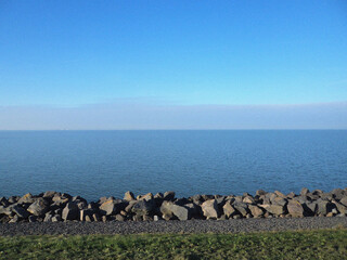 Sea with blue sky and stones. Beautiful natural flyer, card design. Nature Template for presentation or product