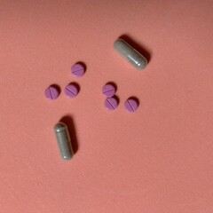 seis píldoras de color rojo con raya en centro y dos cápsulas transparentes con polvo color marrón. farmacia, química, medicina © Elena G. Madrid