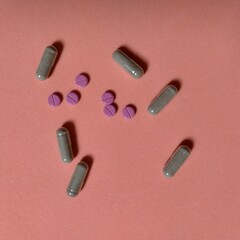 seis píldoras de color rojo con raya en centro y seis cápsulas transparentes con polvo color marrón. farmacia, química, medicina © Elena G. Madrid