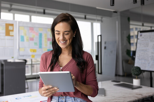 Smiling professional woman using tablet for professional correspondence
