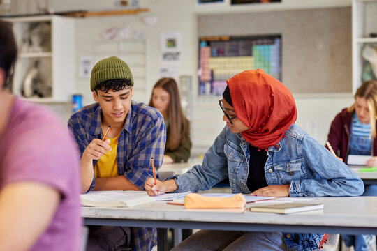 Teen students collaborating in class at high school