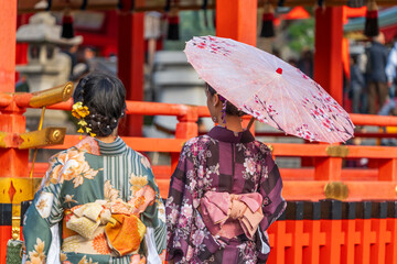Japanese women wearing traditional kimono clothes and holding umbrella at shrine in Kyoto. Japan