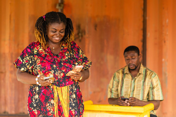 Fototapeta premium Mobile money (MoMo), Happy customer holding cash after withdrawing transaction from an agent.