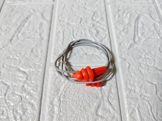 ear plugs photographed closeup, with a textured white background