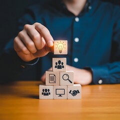 Person holding a wooden block with a light bulb icon, representing an idea