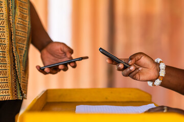 Mobile money (MoMo) in Africa. Digital funds transfer and payments using mobile phones. Fintech, financial inclusion, and cashless transactions. © Roger