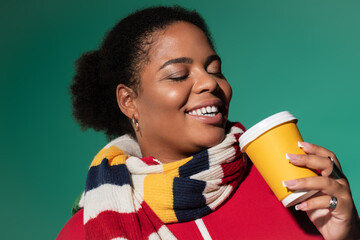 Stylish plus size woman enjoys a warm drink in a trendy autumn outfit