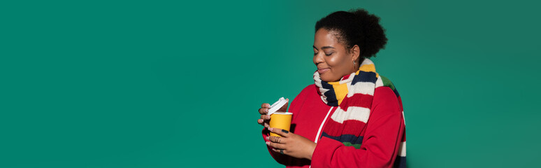 Stylish plus size african american woman enjoying a warm drink in autumn setting