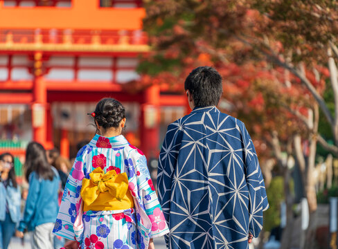 Couple wearing traditional japanese kimono clothes walking towards shrine in Kyoto 