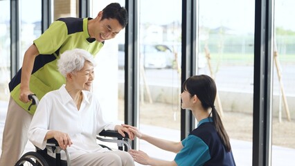 Obraz premium 介護施設で挨拶をする高齢者と介護士
