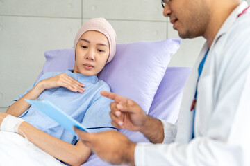 Fototapeta premium Male doctor visiting female cancer patient with care and compassion in hospital room. Oncology support medical consultation healthcare and hope. Doctor reporting medical test results to the patient