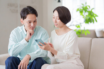 Obraz premium スマホを見る夫婦・カップル