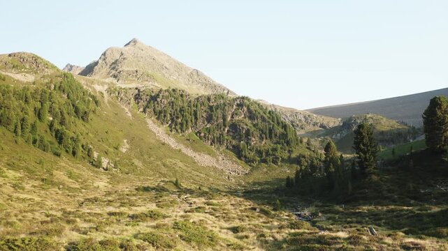 Flying forward through alpine ridges and valleys at sunset in K&uuml;htai, Austria. A warm, peaceful shot perfect for intros, nature, or cinematic storytelling.