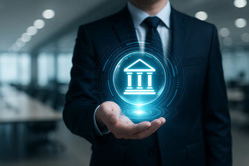 Businessman holding a glowing digital bank or government building icon representing finance, legal, or institutional technology and future digital services