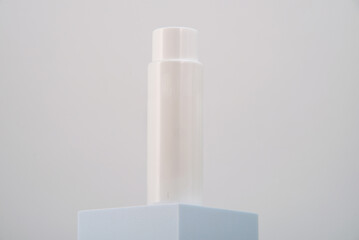 Minimalist white cylinder on the blue pedestal