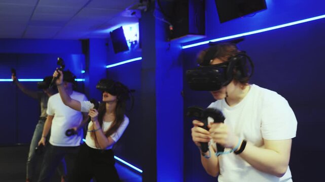 Young guy with handheld controllers in hands clearly excited and engaged in virtual world experiencing through VR glasses covering face. Concept of immersion and interactivity in game