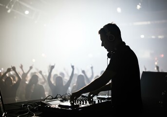 Energetic DJ spinning tracks for an ecstatic crowd at a live music festival, silhouetted against bright stage lights