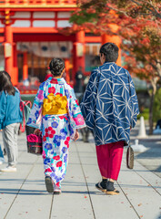 Couple wearing traditional japanese kimono clothes walking towards shrine in Kyoto 