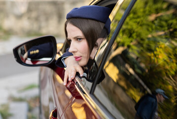 Attractive young female driver in casual outfit, driving car, road safety and transportation theme.Young woman driving car. Travel concept.