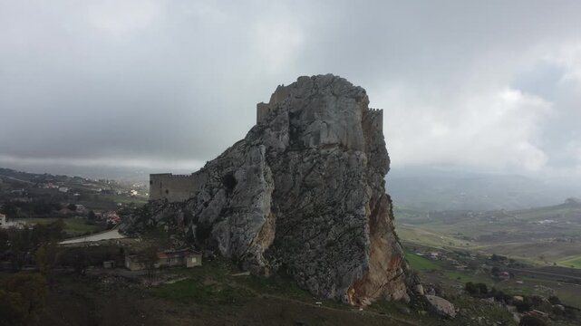 Aerial 4k drone footage of Mussomeli Castle in Sicily, Italy, featuring the historic fortress, dramatic misty atmosphere, surrounding hills, and panoramic views of the landscape