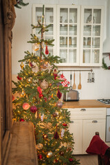 Classical Christmas decorated interior kitchen. Modern classic style interior design apartment dining room and Christmas tree with red golden ornament decorations. Christmas eve at home