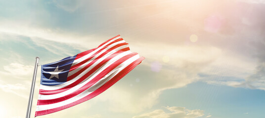 Liberia  flag waving proudly under a bright sky with text happy independence day. Liberia national...