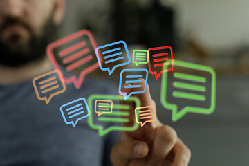 Man's hand pointing at virtual chat bubbles, representing online communication, messaging and social networking. Concept of connection.