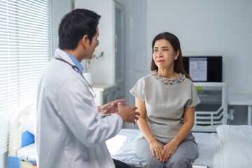 Fototapeta premium Doctor explaining diagnosis to senior patient in hospital room