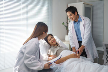 Obraz premium Doctors visiting patient in hospital bed discussing medical records