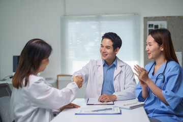 Obraz premium Doctors shaking hands after successful surgery in hospital meeting room